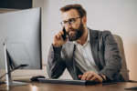 young-business-man-talking-phone-working-computer.jpg